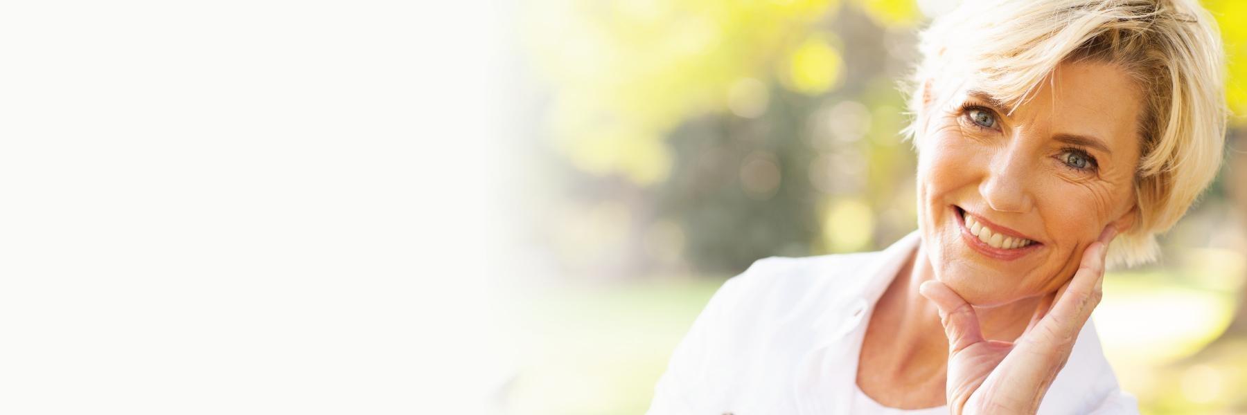 older woman smiling after getting dental implants