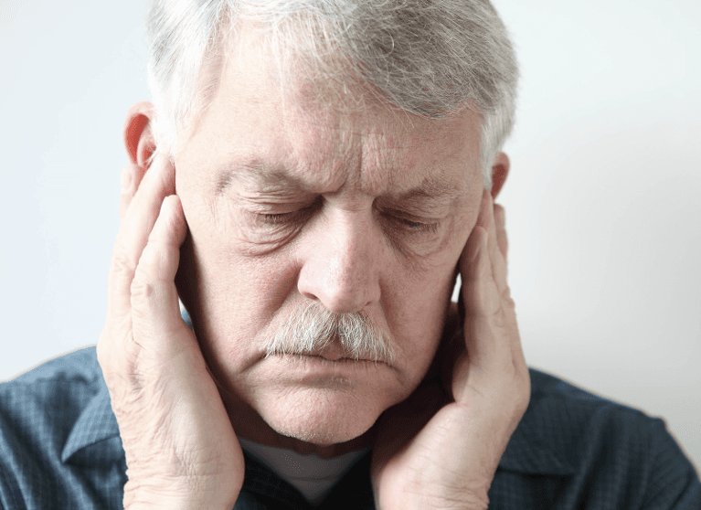 A Man with holding his jaw due to a toothache at Wisconsin smiles, Milwaukee