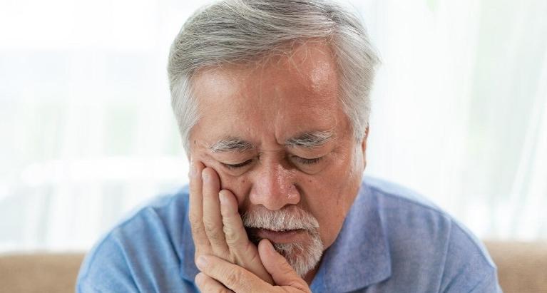 man holding jaw after he broke a crown