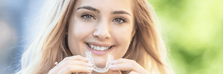 A lady holding Invisalign clear aligners at wisconsin smile, Milwaukee