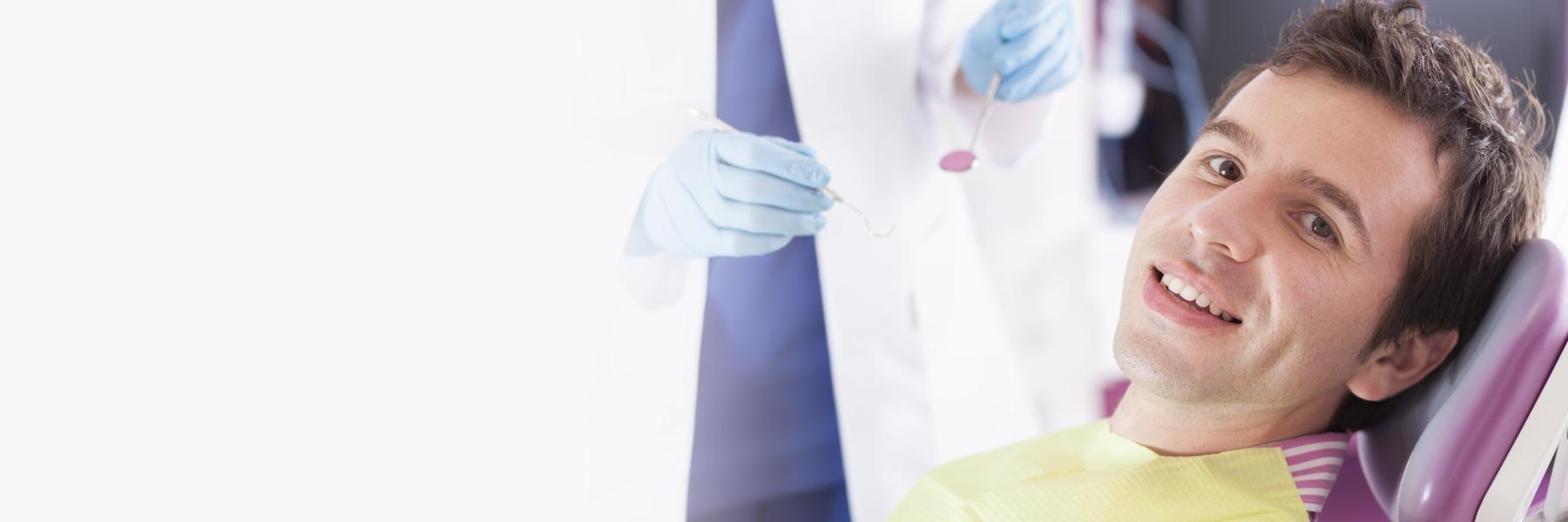 man smiling in chair after emergency dental care